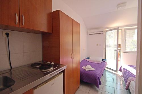 uma cozinha com um lavatório e uma mesa num quarto em Villa San Marco em Budva
