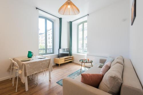 un salon avec un canapé et une table dans l'établissement Appartements centre-ville - Wifi - Cuisine tout équipée - Lave-linge, à Pau