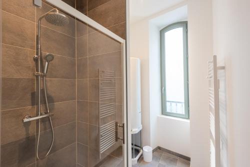 baño con ducha y puerta de cristal en Appartements centre-ville - Wifi - Cuisine tout équipée - Lave-linge, en Pau