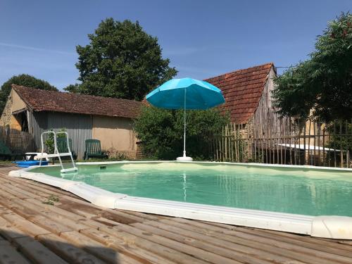 - un parasol bleu au-dessus de la piscine dans l'établissement Gîte du Meynet, à Saint-Cyprien