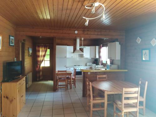 uma cozinha e sala de jantar com mesa e cadeiras em Chalet bois em Neuville