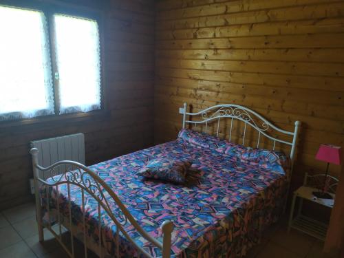 um quarto com uma cama com uma almofada em Chalet bois em Neuville