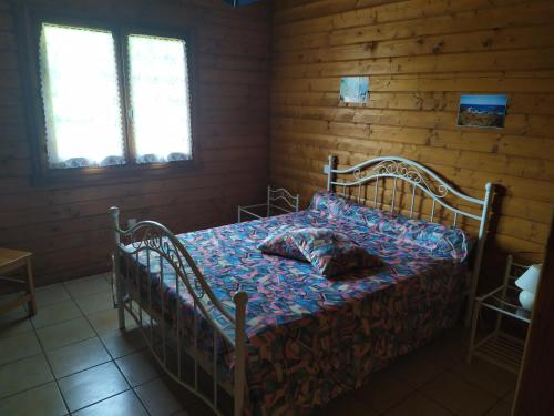 une chambre avec un lit dans une pièce en bois dans l'établissement Chalet bois, à Neuville
