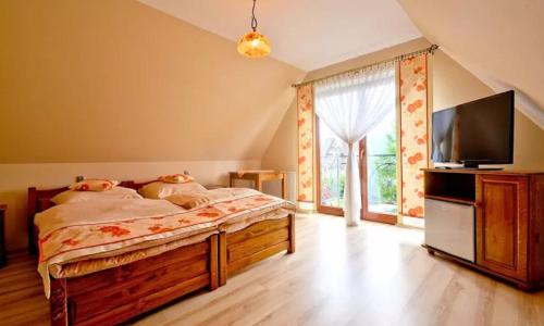 a bedroom with a bed and a flat screen tv at Góralski Pałacyk in Biały Dunajec