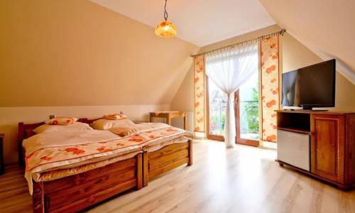 sypialnia z łóżkiem i telewizorem z płaskim ekranem w obiekcie Góralski Pałacyk w Białym Dunajcu