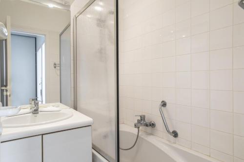 ein weißes Bad mit einem Waschbecken und einer Dusche in der Unterkunft L'Ar Timon in Saint-Cast-le-Guildo
