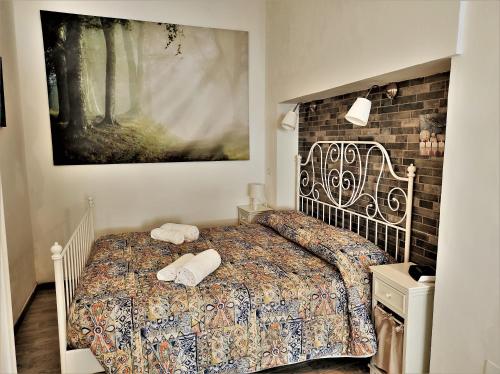 シラクーサにあるAppartamento Galateaのベッドルーム1室(ベッド1台付)が備わります。壁に絵が飾られています。