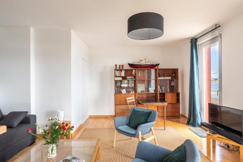a living room with a couch and a glass table at L'Ar Timon in Saint-Cast-le-Guildo