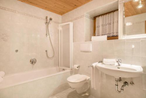 biała łazienka z toaletą i umywalką w obiekcie Ferienparadies Sabina Schlern w mieście Alpe di Siusi