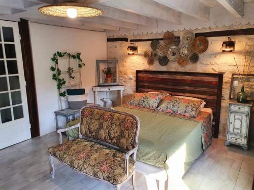 1 dormitorio con 1 cama grande y 1 silla en La Fontenelle Chambres d'Hôtes, en Sainte-Sévère