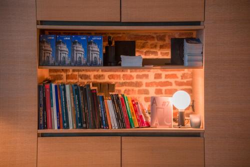 a book shelf with books and a lot of books at Hotel Neuvice in Liège