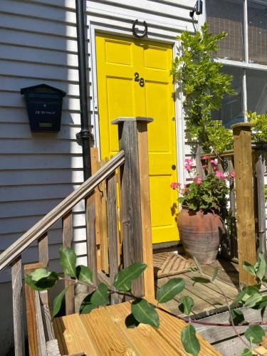 a yellow door on a house with a porch at King Street Accomadation in Margate