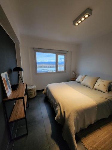 una camera con un grande letto e una finestra di LiveUshuaia Beagle View Apartmento 2 dormitorios a Ushuaia