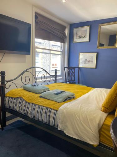 a bedroom with a bed with yellow and blue walls at King Street Accomadation in Margate