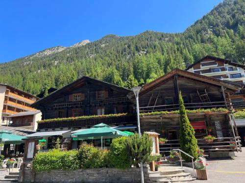 a large building with a mountain in the background at Au Vieux Champex in Champex