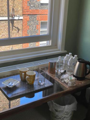 a table with glasses and water bottles and a window at King Street Accomadation in Margate