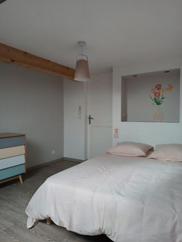 - une chambre avec un grand lit blanc et une commode dans l'établissement Gîte 14 personnes à proximité du Puy du Fou 