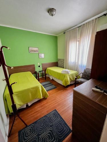 a room with two beds in a room with green walls at Hotel Uruguay Brasil in Rivera