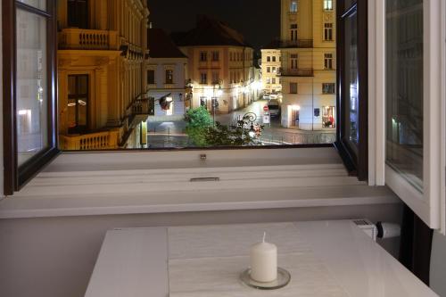 a candle sitting on a table in front of a window at Atrium Apartments in Brno