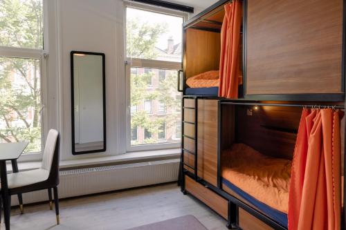 een slaapkamer met een stapelbed en een spiegel bij Recharge Hostel in Rotterdam