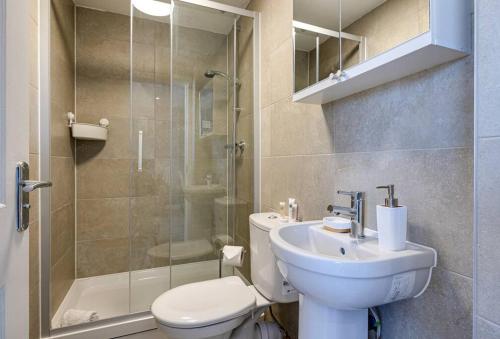 y baño con aseo, lavabo y ducha. en Entire 1 bed apt in the centre of Stockport, en Stockport