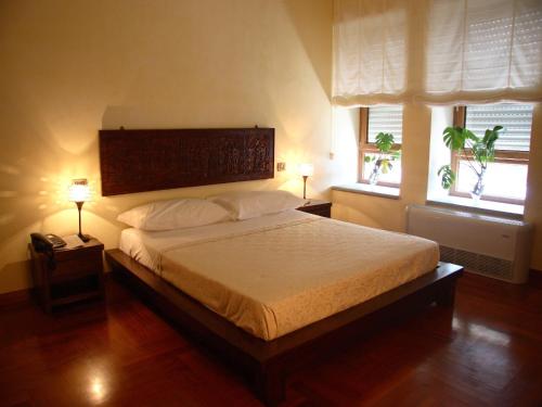 una camera da letto con un grande letto con due finestre di Casa Dei Mercanti Town House a Lecce