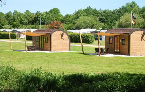 a couple of small wooden cottages in a park at Lovely Home In Süsel With Lake View in Süsel