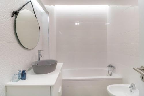 a white bathroom with a sink and a mirror at #048 Sunrise by Home Holidays in Brejos