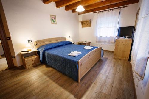 パルッツァにあるLa Marmote Albergo Diffuso di Paluzza Clomeのベッドルーム1室(青い掛け布団付きのベッド1台付)
