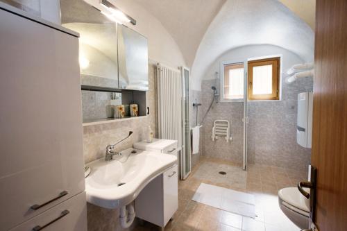 y baño blanco con lavabo y ducha. en La Marmote Albergo Diffuso di Paluzza Clome, en Paluzza