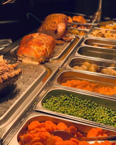 a buffet with many trays of different types of food at Tyacks Hotel in Camborne
