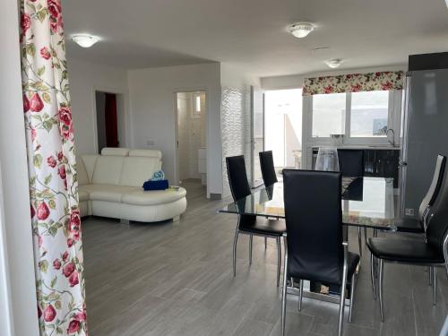 a dining room and living room with a table and chairs at Adeje Deluxe Villas Santa Mónica in Adeje