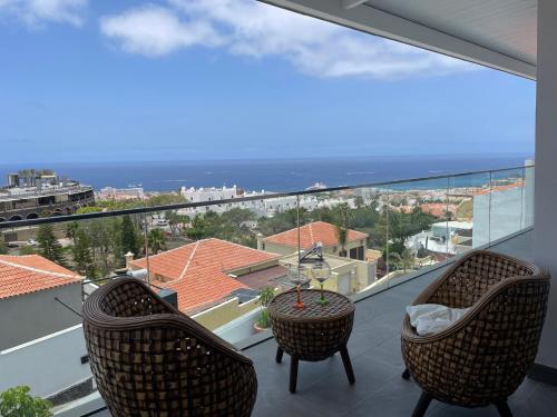 a balcony with two chairs and a view of the ocean at Adeje Deluxe Villas Santa Mónica in Adeje