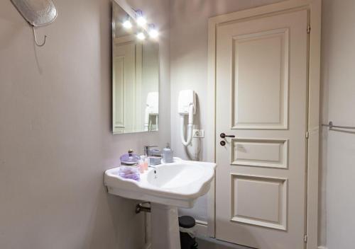 a white bathroom with a sink and a mirror at Palazzo Vittoli - Irpinia in Castelfranci