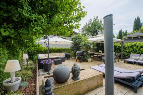 a backyard with a wooden deck with furniture and an umbrella at Waldvilla BERGSEE in Bodensdorf