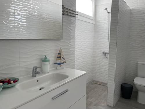 a white bathroom with a sink and a toilet at Adeje Deluxe Villas Santa Mónica in Adeje