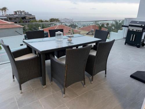 a dining table and chairs on a balcony with a view at Adeje Deluxe Villas Santa Mónica in Adeje