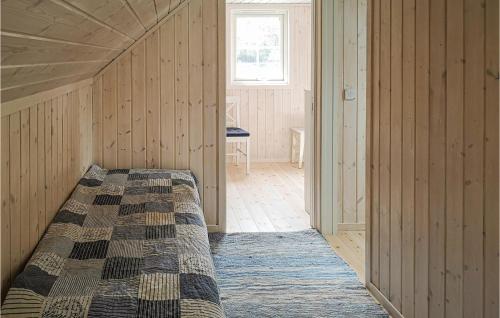 sypialnia z łóżkiem w pokoju z drewnianymi ścianami w obiekcie Gorgeous Home In Lyngdal With Kitchen w mieście Lyngdal