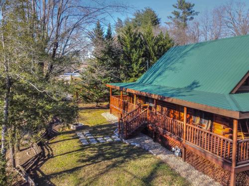 a house with a green roof and a yard at RiverStone Condo Resort & Spa in Pigeon Forge