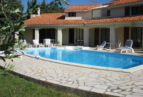 uma piscina em frente a uma casa em Villa de 6 chambres avec piscine privee spa et jardin clos a Argeles sur Mer em Argelès-sur-Mer