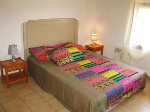 uma cama com um edredão colorido num quarto em Villa de 6 chambres avec piscine privee spa et jardin clos a Argeles sur Mer em Argelès-sur-Mer