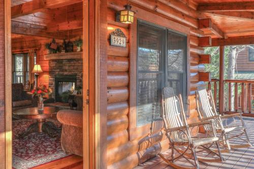 a porch of a cabin with two chairs and a table at RiverStone Condo Resort & Spa in Pigeon Forge