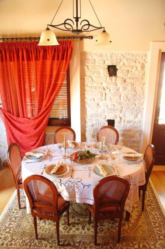 a dining room with a white table and chairs at Villa Votsalo in Kiónion