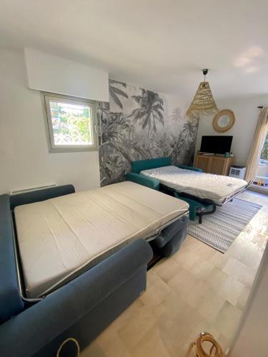 une chambre avec deux lits et un canapé dans l'établissement La Beau'M Juan Les Pins centre ville 200m de la mer terrasse et jardin, à Juan-les-Pins