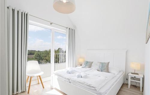 um quarto branco com uma cama e uma grande janela em Mareby em Olpenitz