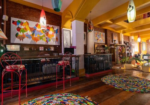 a restaurant with a bar with red stools at Pousada Des Arts in Salvador