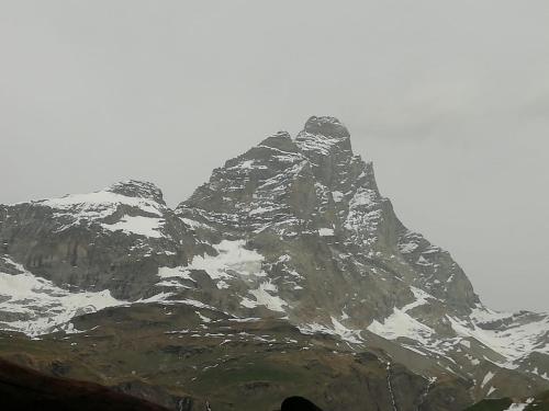 a large mountain with snow on it at Condominio Escargot in Breuil-Cervinia