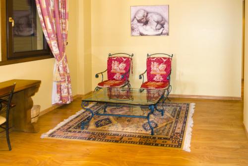 a living room with two chairs and a glass table at Complejo Hostelero Paladium in Villamartín