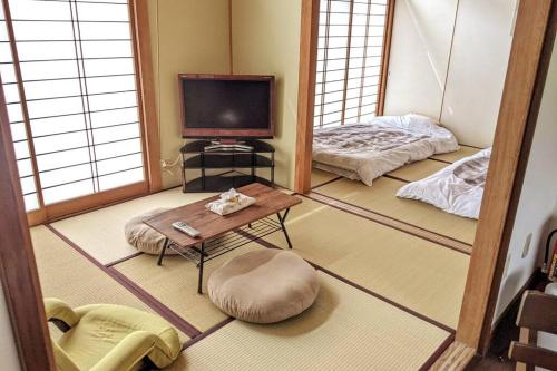 a living room with a tv and a table at Oiwake House 1B in Karuizawa