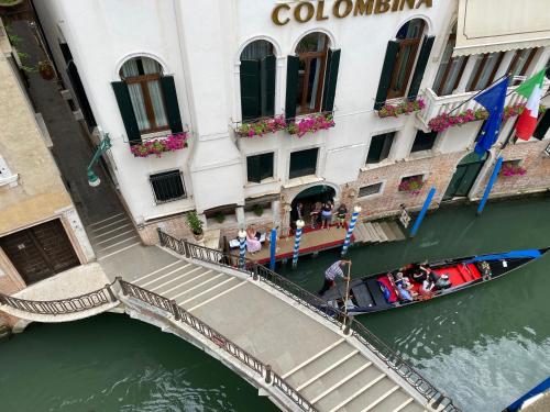 a canal with a gondola in the water next to a building at Anzolo Palace - Rooms & Apartments in Venice